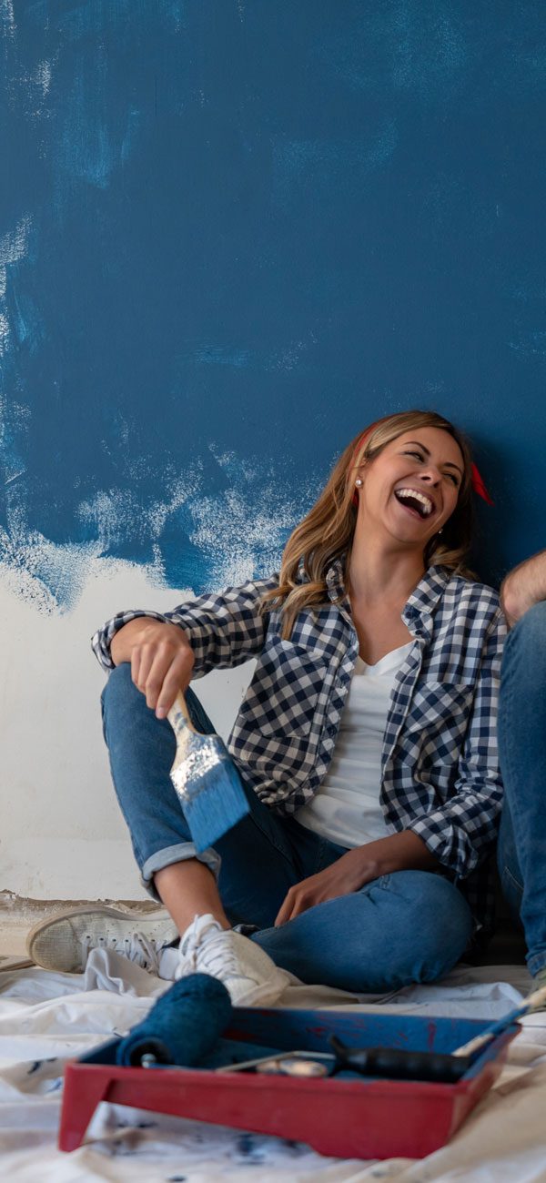 Giovane coppia scherza mentre dipinge una parete